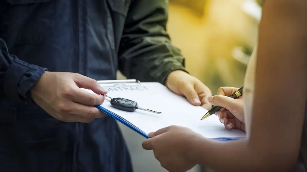 Cliente assinando o contrato do veículo com o despachante